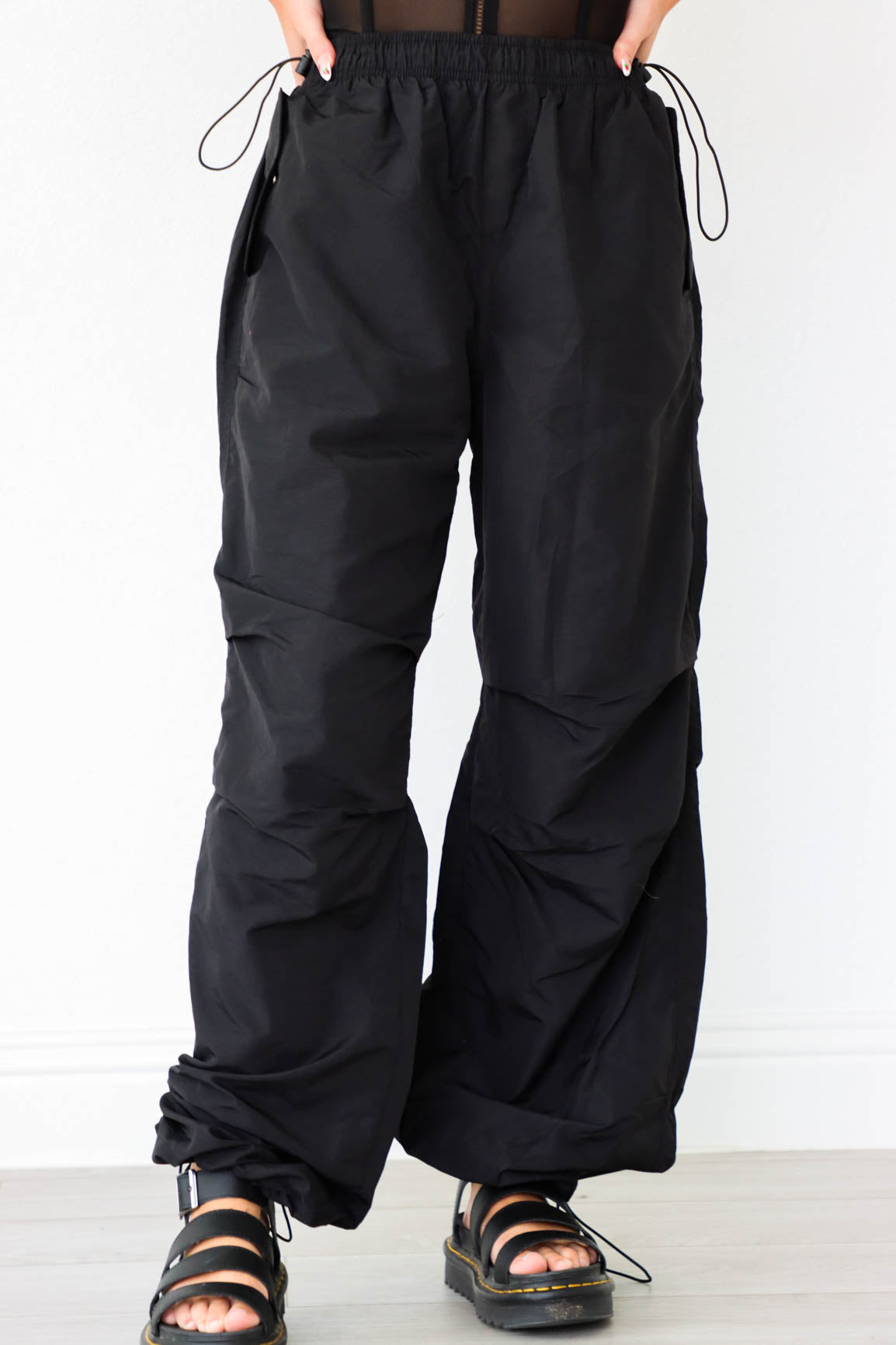 girl wearing black cargo parachute pants