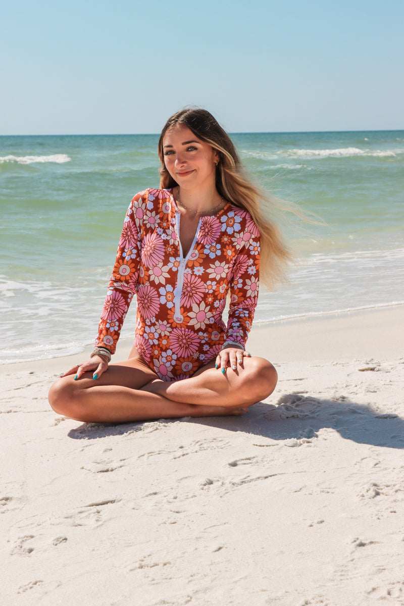 girl wearing floral one piece swimsuit with long sleeves