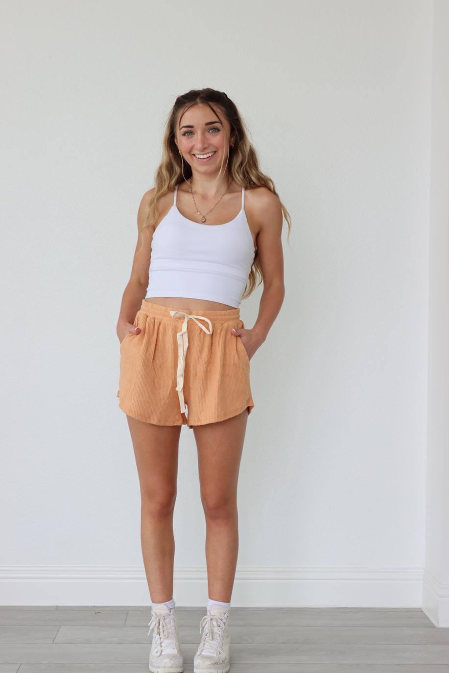 girl wearing orange comfy lounge shorts with cream drawstring