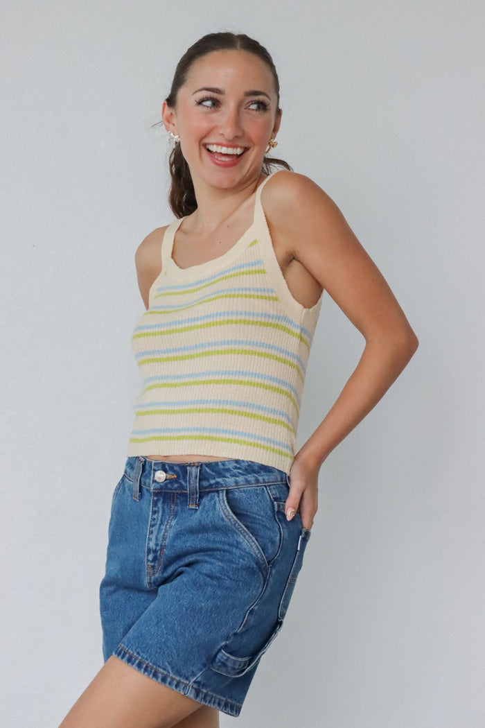 girl wearing yellow, blue, and green striped tank top