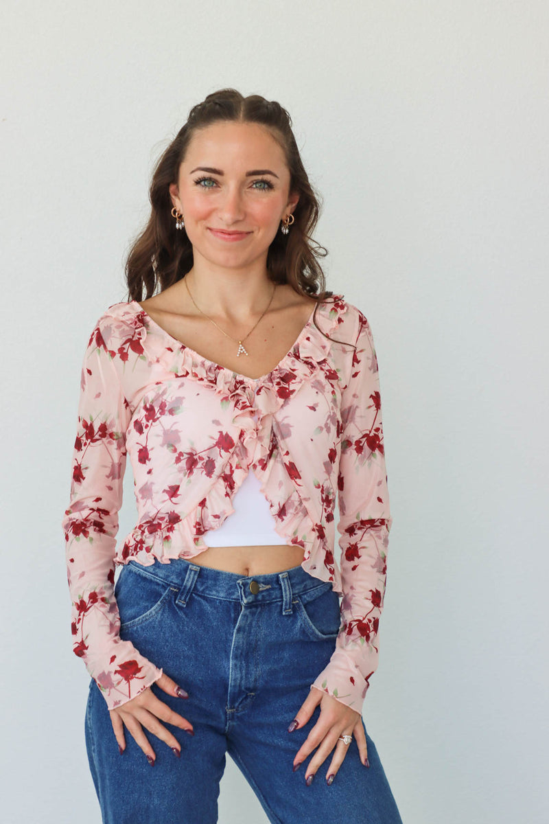 girl wearing sheer pink floral long sleeve top