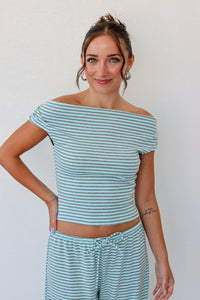 A woman modeling an off the shoulder light blue striped top and matching pants 