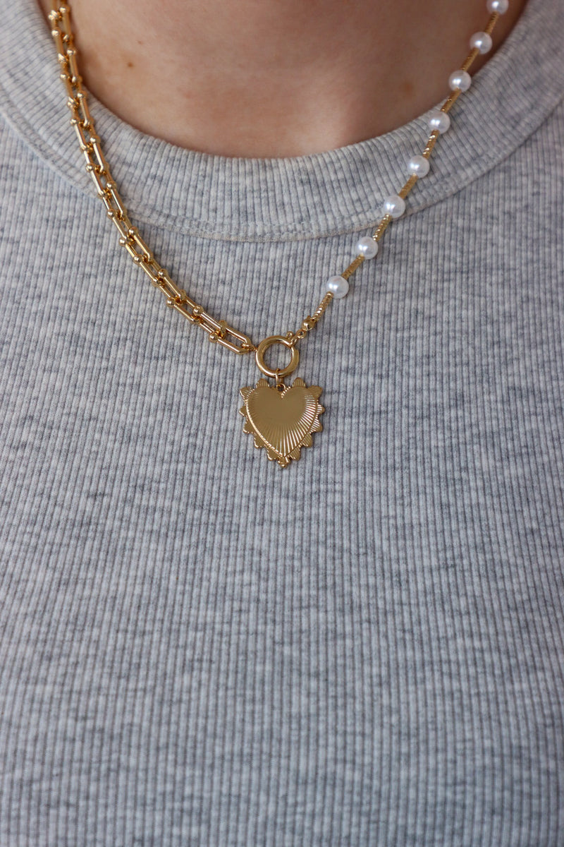 girl wearing gold and pearl heart chunky necklace