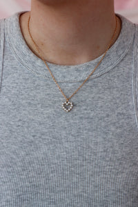 girl wearing gold and pearl heart necklace