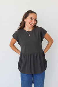 girl wearing black waffle knit peplum top