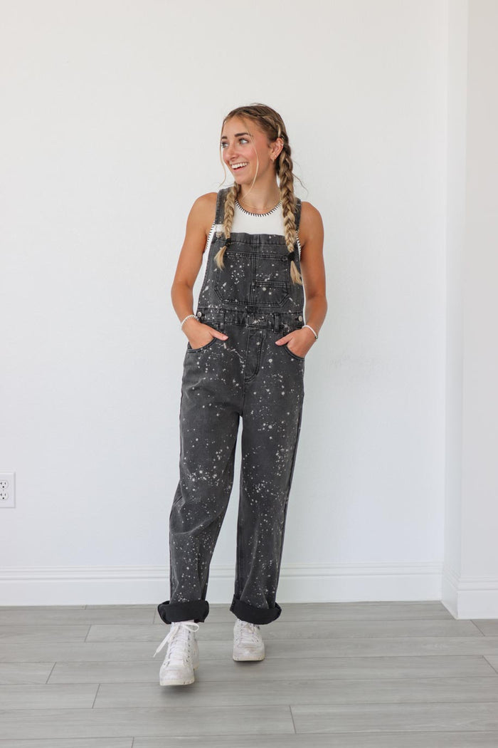 girl wearing black long overalls with paint splatter detailing