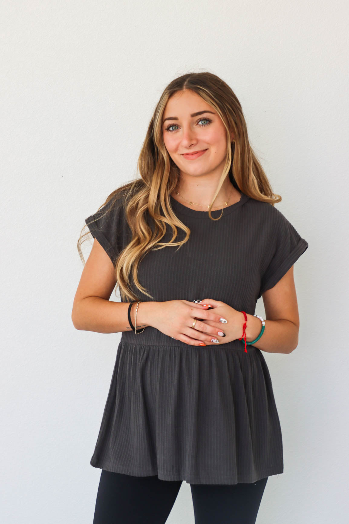 girl wearing black waffle knit peplum top