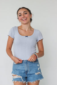 girl wearing light blue t-shirt with bow detailing