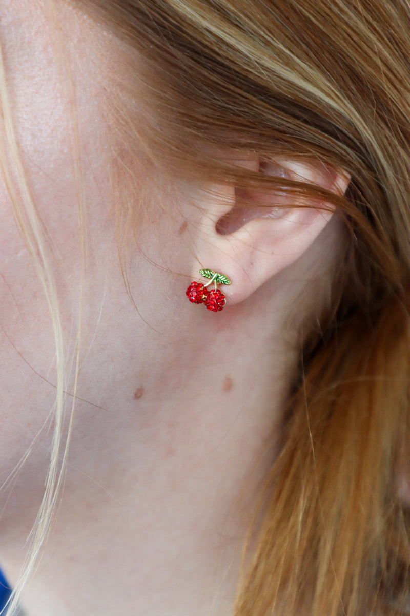 girl wearing cherry stud earrings