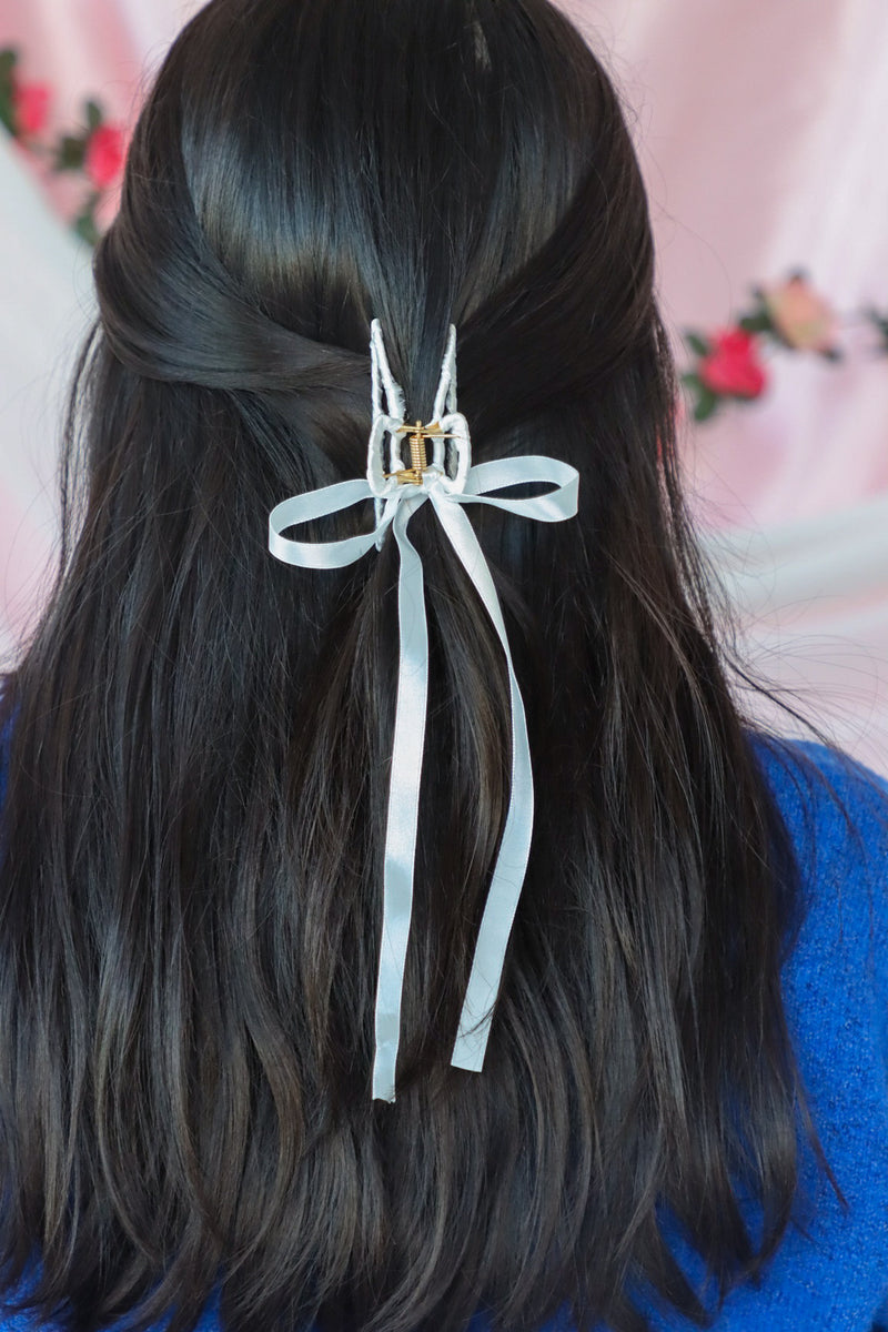 girl wearing white silk hair bow clip