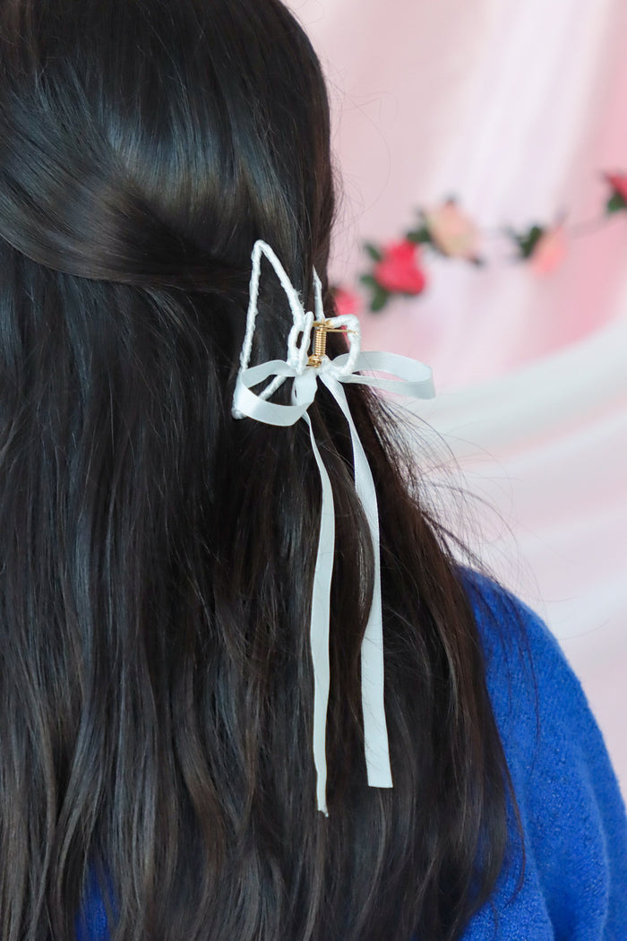 girl wearing white silk hair bow clip