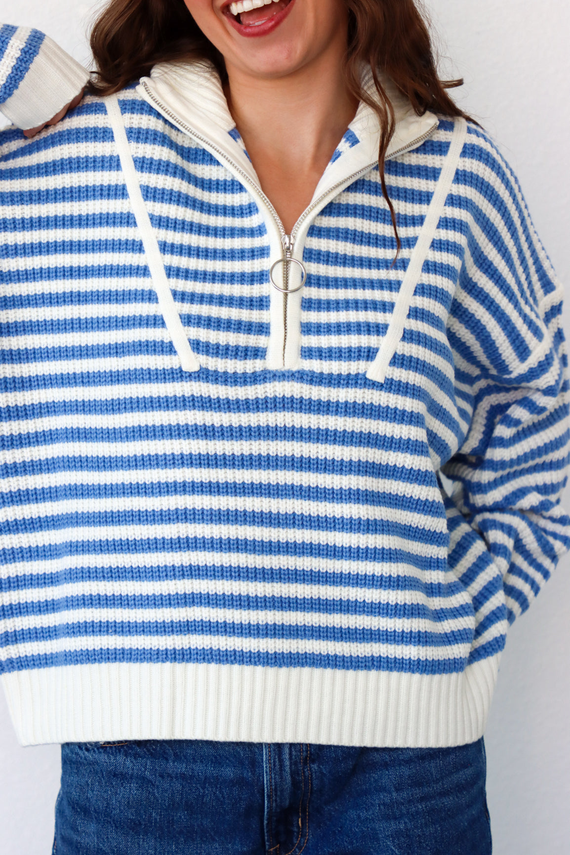 Person wearing a blue and white striped sweater with a white collar.