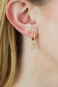 girl wearing gold cowboy boot huggie earrings