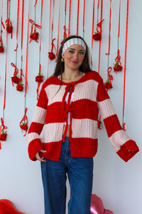 Person wearing a red and white striped sweater with a decorative background.