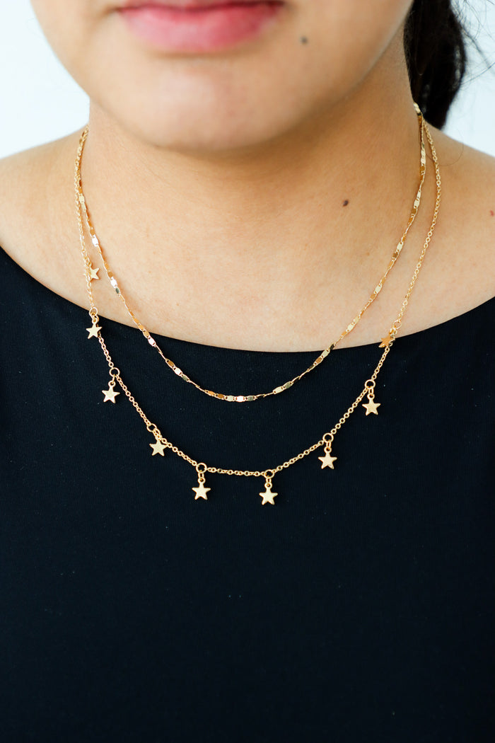 girl wearing gold star necklace