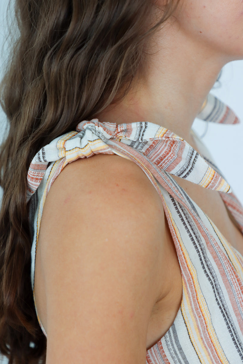 Close-up of a person wearing a striped sleeveless top with a blurred background