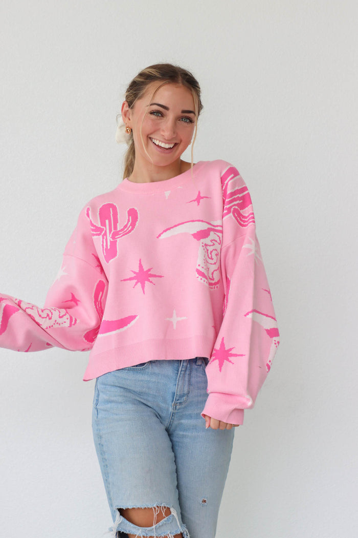 girl wearing pink sweater with western print