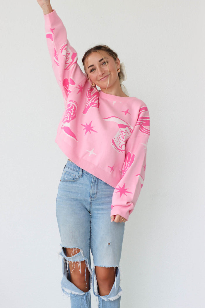 girl wearing pink sweater with western print