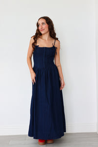 Woman wearing a navy blue dress against a white background