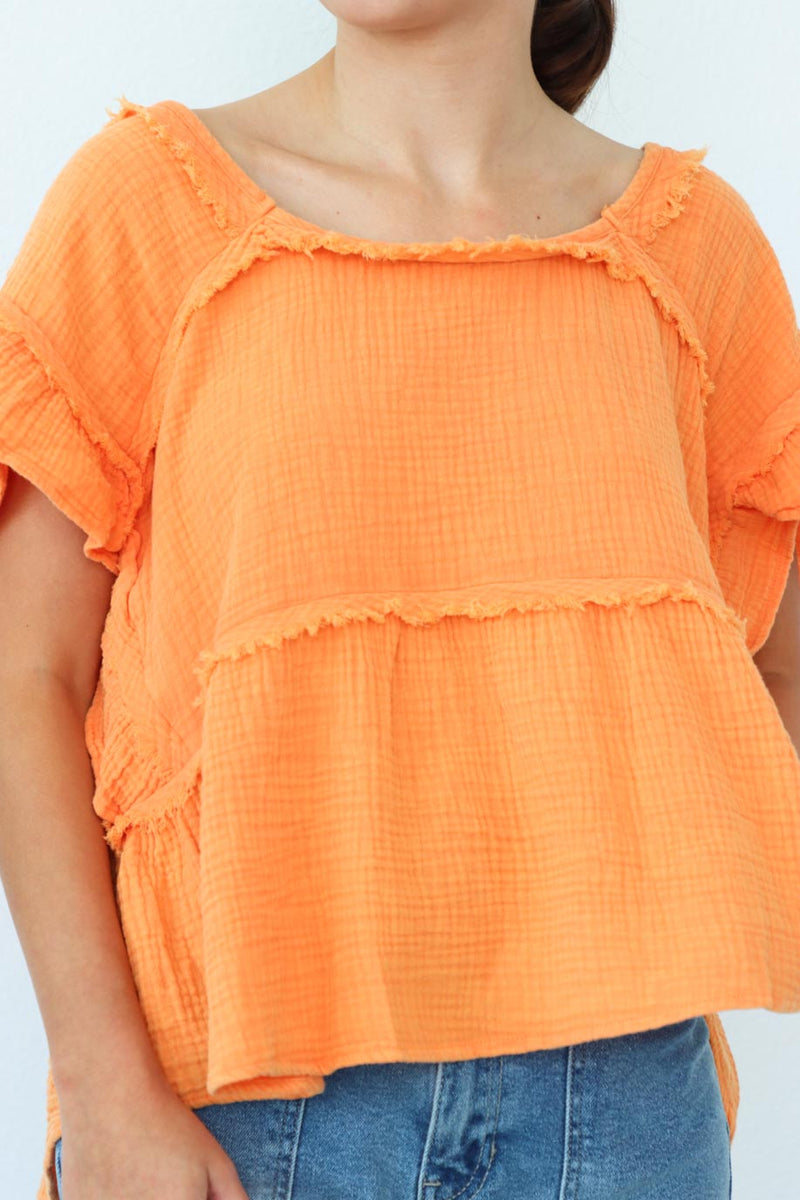 girl wearing orange short sleeved top