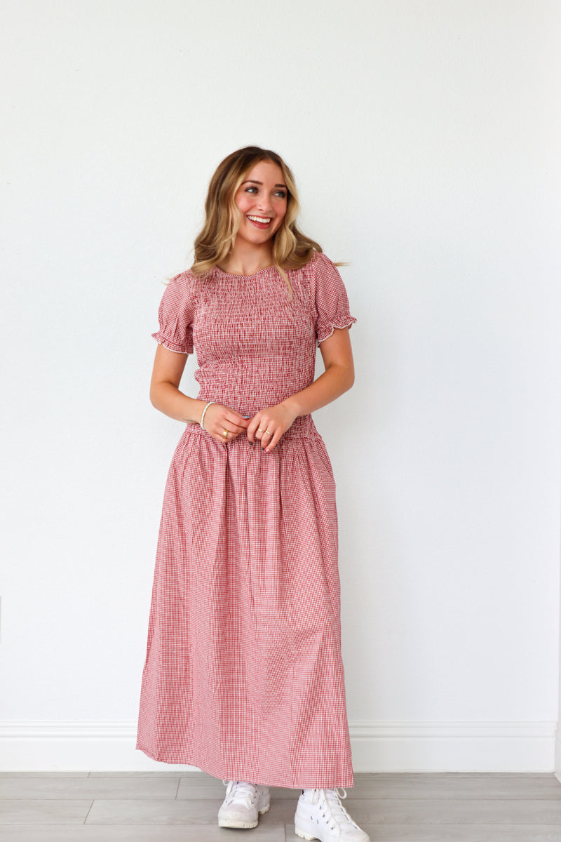 Woman wearing a pink dress standing against a white background
