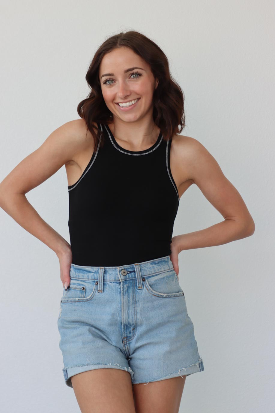 girl wearing black tank top bodysuit with white contrast stitch detailing