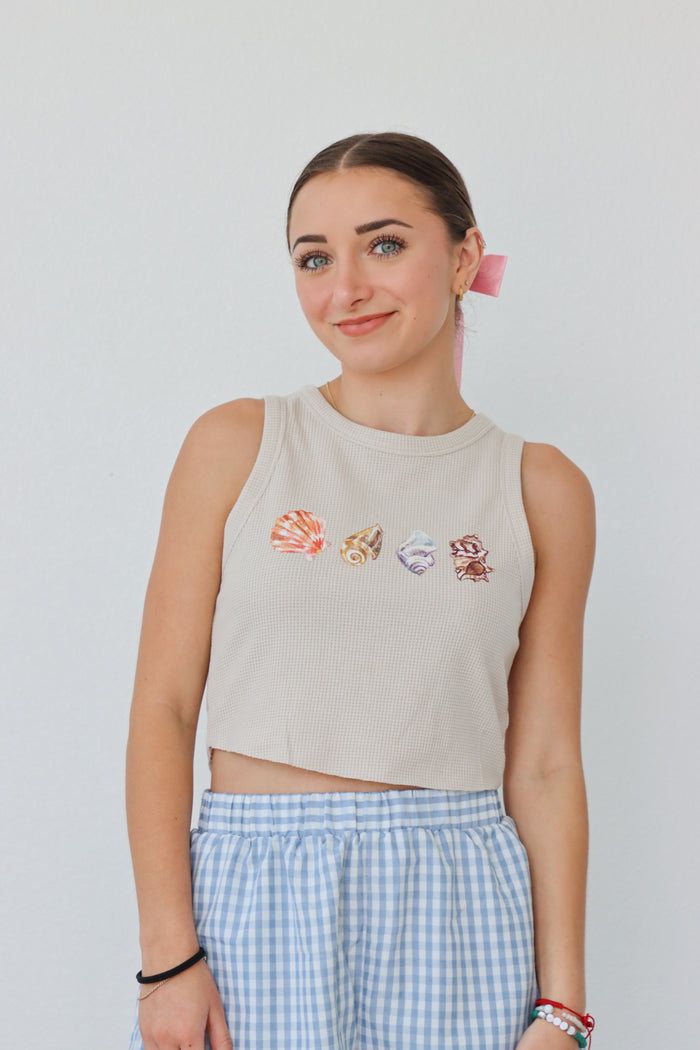 girl wearing tan waffle knit tank top with screenprinted seashells