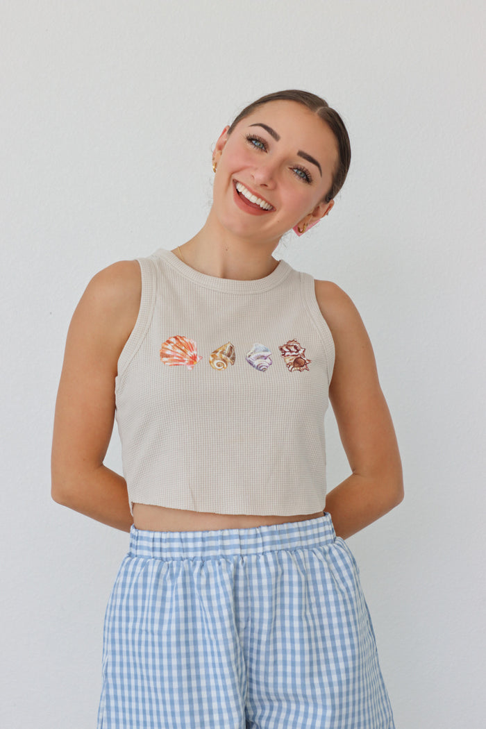 girl wearing tan waffle knit tank top with screenprinted seashells