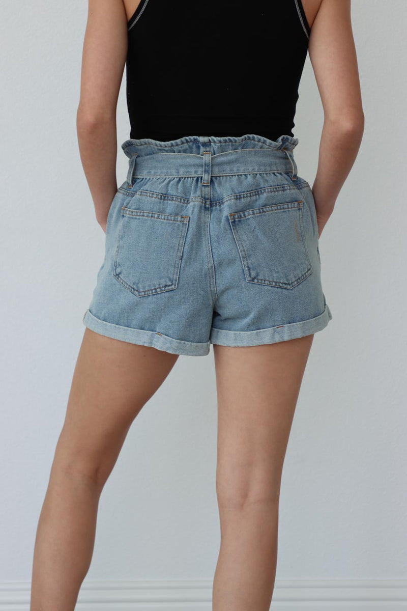 back of girl wearing light blue denim shorts with tie waist