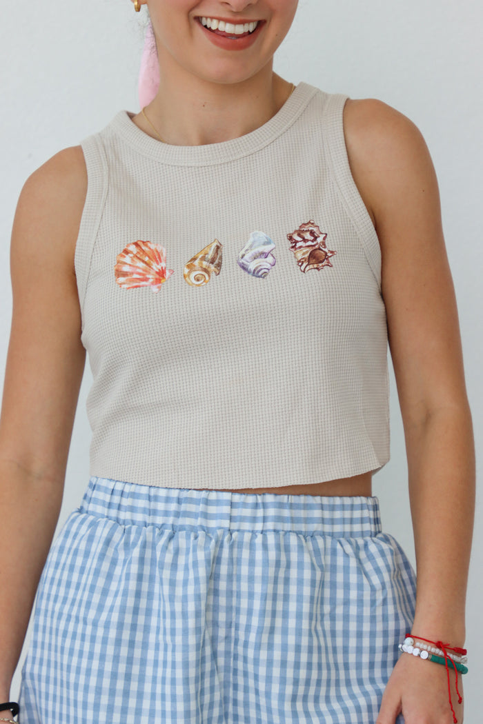 girl wearing tan waffle knit tank top with screenprinted seashells
