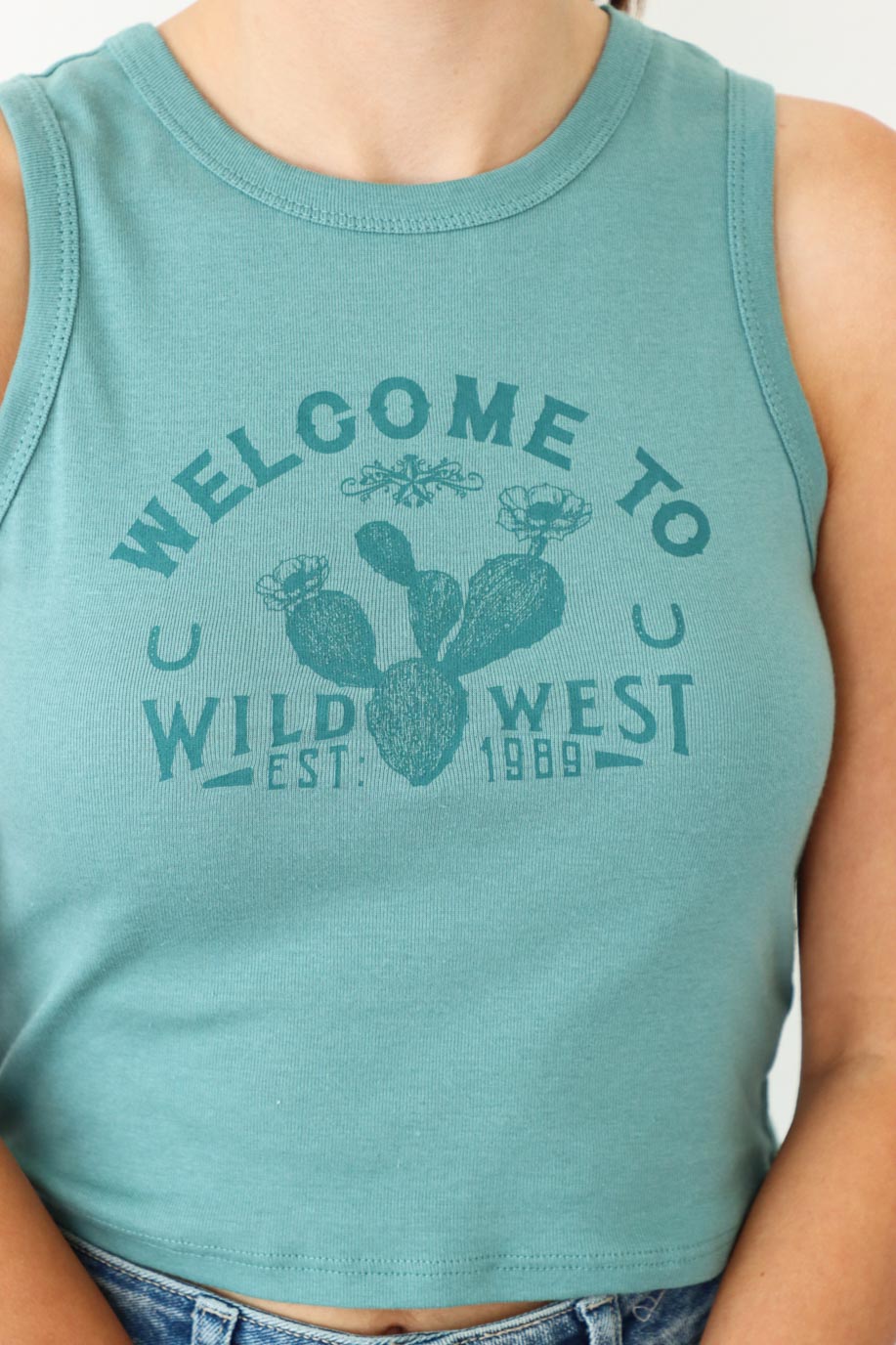 girl wearing "welcome to the wild west" teal tank top