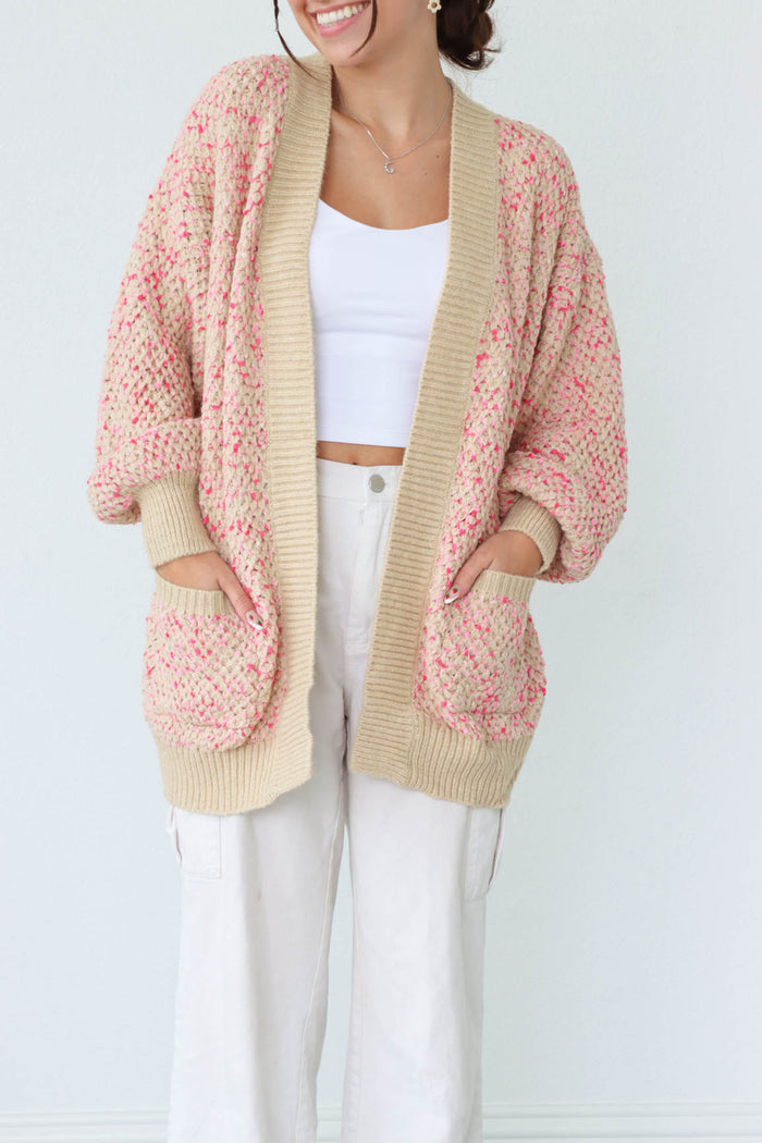 girl wearing pink and cream knit cardigan