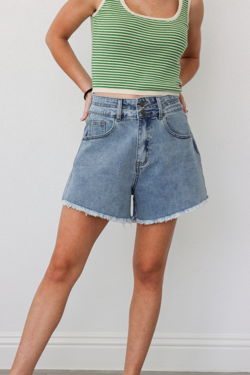 girl wearing medium wash denim shorts