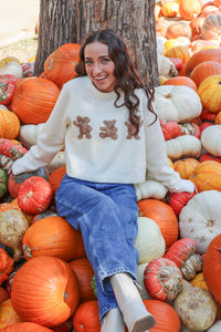 girl wearing cream bear sweater