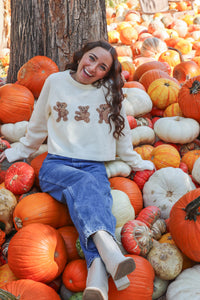 girl wearing cream bear sweater