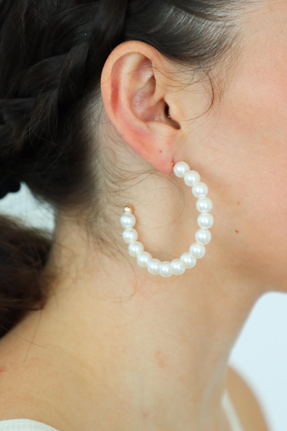 girl wearing pearl hoop earrings