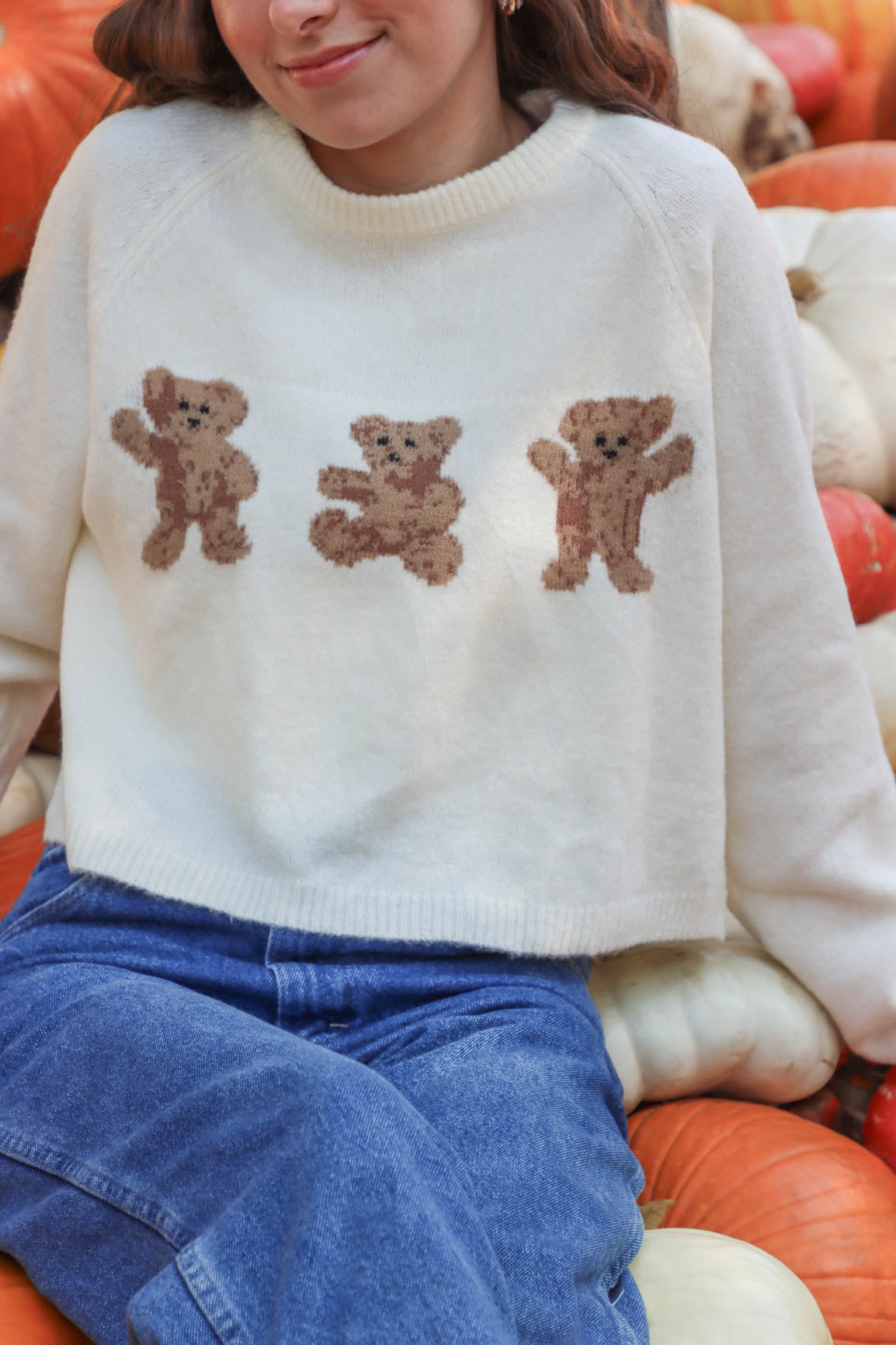 girl wearing cream bear sweater