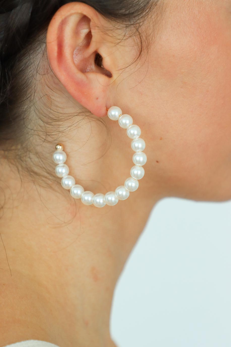 girl wearing pearl hoop earrings