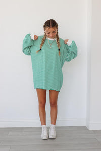 girl wearing green striped oversized long sleeve shirt