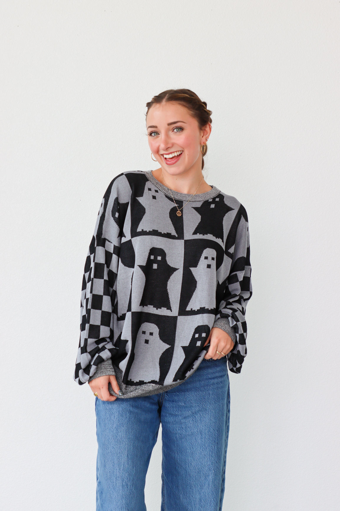 girl wearing gray and dark gray checker print ghost sweater