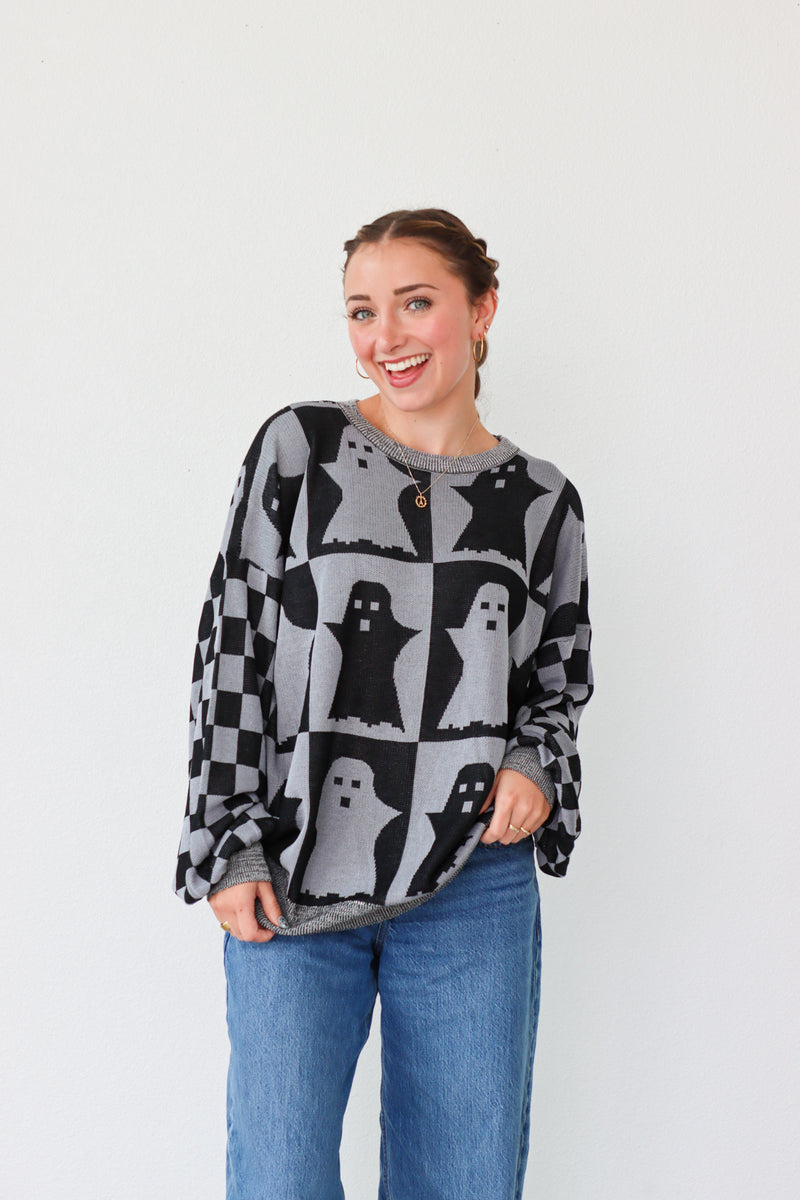 girl wearing gray and dark gray checker print ghost sweater