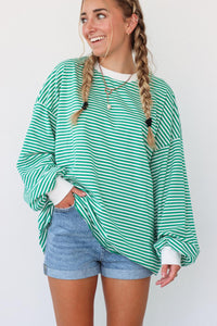 girl wearing green striped oversized long sleeve shirt