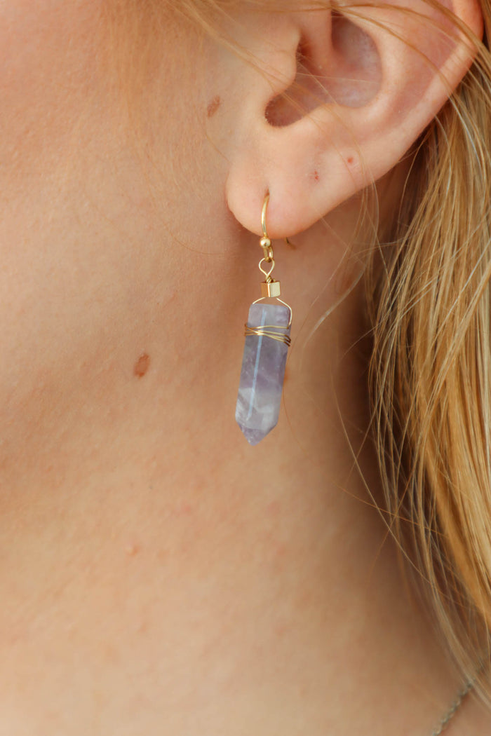 girl wearing purple geod earrings