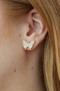 girl wearing gold sparkly butterfly earrings