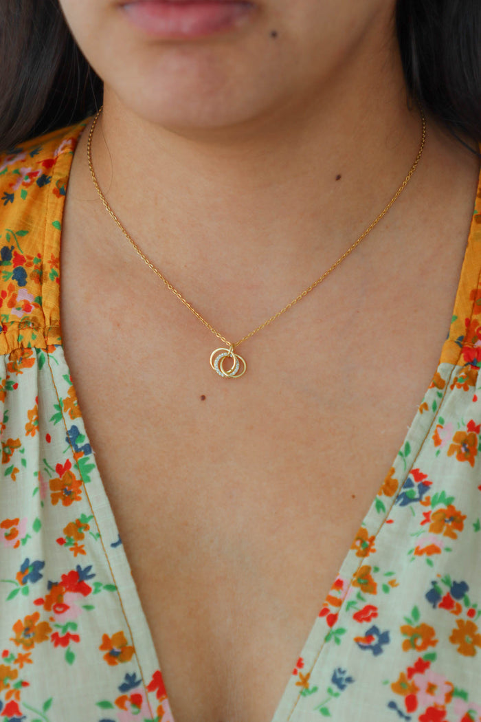 girl wearing gold necklace with intertwined circle pendant