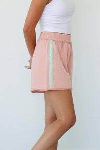 girl wearing pink sweat shorts with grey stripe detailing
