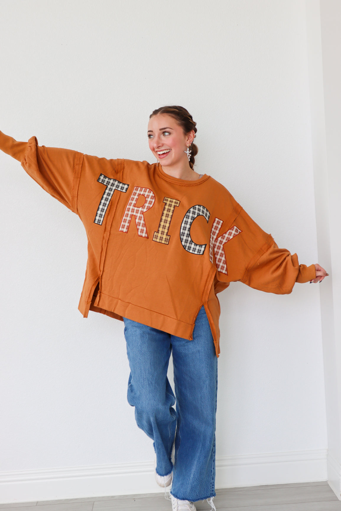 girl wearing orange long sleeve "trick" top