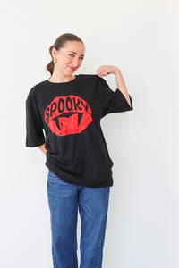 Woman wearing a black t-shirt with a red 'Spooky' design on a white background