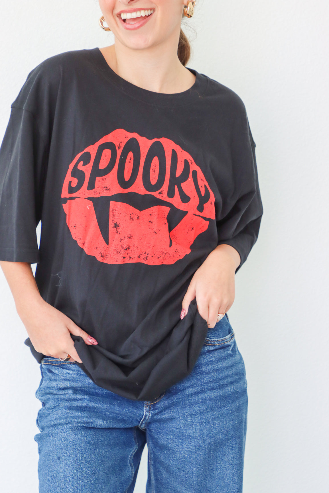 Person wearing a black oversized t-shirt with red 'Spooky' graphic design on a white background