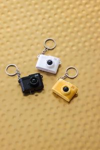 black, white, and yellow camera keychains